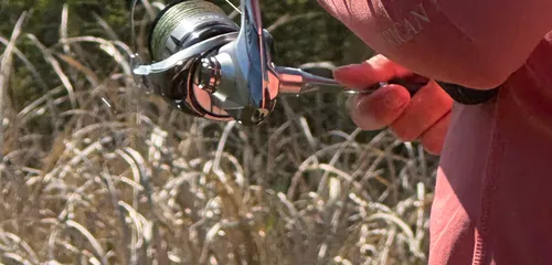 Close-up of a spinning reel and rod while fishing