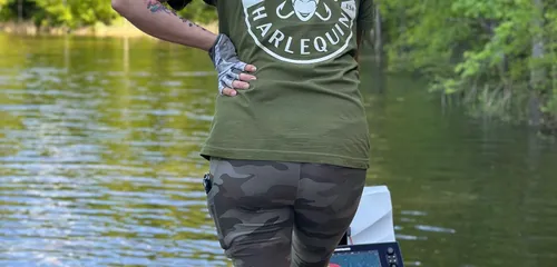 Gina standing on the deck of her boat looking out at the lake