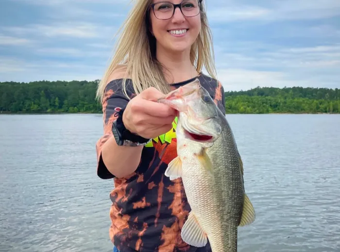 Gina holding a largemouth bass on an NC lake
